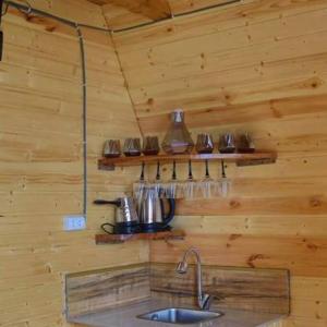 eine Küche mit einem Waschbecken in einer Holzwand in der Unterkunft cottage panorama merisi in Inasharidzeebi