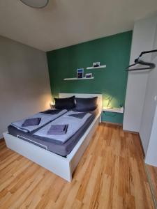 a bedroom with a bed with a green wall at Ferienwohnung zum Hufi in Dahn