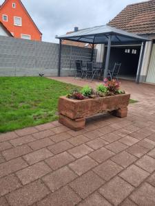 a patio with an umbrella and a bench with flowers at Ferienwohnung zum Hufi in Dahn
