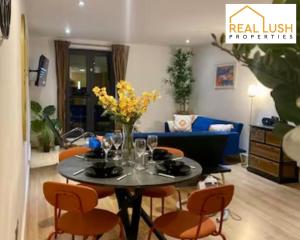 ein Wohnzimmer mit einem Tisch mit Stühlen und einem Sofa in der Unterkunft Real Lush Properties - East Street - Luxury Two-Bedroom Apartment In Leicester in Leicester