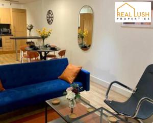 ein Wohnzimmer mit einem blauen Sofa und einem Tisch in der Unterkunft Real Lush Properties - East Street - Luxury Two-Bedroom Apartment In Leicester in Leicester