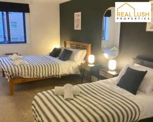 a hotel room with two beds and a mirror at Real Lush Properties - East Street - Luxury Two-Bedroom Apartment In Leicester in Leicester