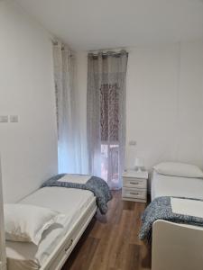 sypialnia z 2 łóżkami i oknem w obiekcie Appartamento Perla w mieście Cologno Monzese