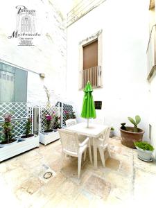 un patio con tavolo, sedie e piante in vaso di Palazzo Mastrovito a Martina Franca