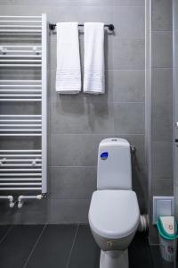 a bathroom with a white toilet and towels at Nina House in Târgu Jiu