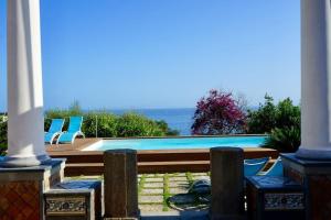 a pool with chairs and the ocean in the background at Villa capri con giardino e piscina in Capri
