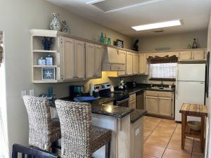 a kitchen with wooden cabinets and a white refrigerator at 126 E Pike home in South Padre Island