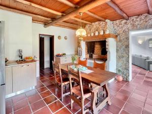 una cucina e una sala da pranzo con tavolo in legno di Quinta Mourada a São Bartolomeu