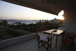 ein Tisch und Stühle auf einem Balkon mit Blick auf das Meer in der Unterkunft VILLA DEEP BLUE in Aghia Marina
