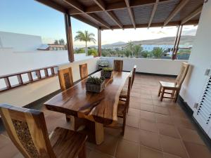 a dining room with a table and chairs on a balcony at Villa Dedalos - A luxury large villa with a heated pool in Puerto Calero in Puerto Calero