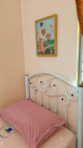 a bed with a pink pillow and a picture on the wall at Hmsty D Hutan Kampung Alor Setar (Muslim) 