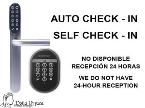 um controlo remoto ao lado de um sinal que lê auto check in auto check in no em Pension Boutique Doña Urraca em Burgos