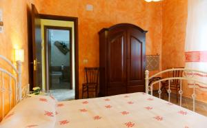 una camera con letto e parete arancione di Domu Severino camere a Pula