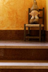 um urso de peluche sentado numa cadeira num quarto em Domu Severino camere em Pula