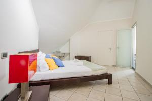 Un dormitorio con una cama con almohadas de colores. en [Loft Eugenio] - *Large and bright apartment*, en Turín