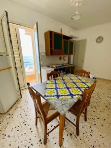 een keuken met een tafel met stoelen en een koelkast bij Holiday Marty&kalos in Sciacca