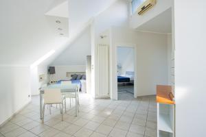 Habitación blanca con mesa, sillas y cama en [Loft Eugenio] - *Large and bright apartment*, en Turín