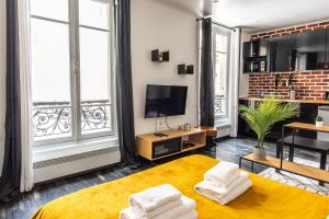 巴黎Design Studio near metro and Eiffel Tower的带床和电视的客厅