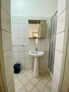 uma casa de banho branca com um lavatório e um espelho em Holiday Marty&kalos em Sciacca