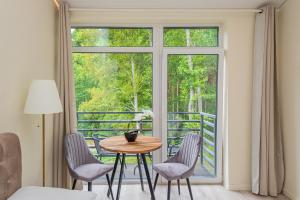 パランガにあるSeaside apartments 2のテーブルと椅子、窓が備わる客室です。