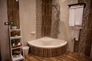 bagno con vasca, doccia e asciugamani di Palm Pyramids View INN a Il Cairo