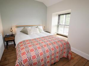 a bedroom with a bed with a red and white bedspread at Glan William in Dolwyddelan