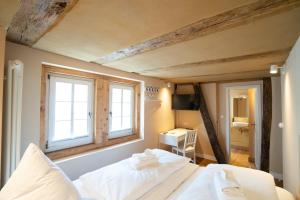 um quarto com 2 camas brancas e 2 janelas em Boutique-Hotel Stadtherberge Wetzlar em Wetzlar