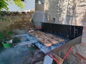 a grill with meat and tongs cooking on it at La Panoramica in Avenale