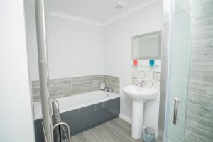 łazienka z wanną i umywalką w obiekcie Tig Cottage - a rural, quirky, pet friendly 2 bedroom cottage near Ballantrae w mieście Ballantrae +37 zdjęć