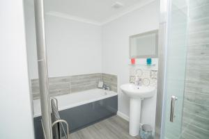 a bathroom with a bath tub and a sink at Tig Cottage - a rural, quirky, pet friendly 2 bedroom cottage near Ballantrae in Ballantrae