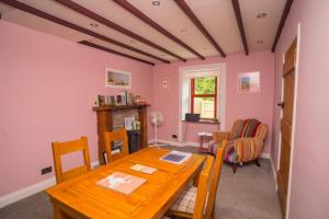 a dining room with a wooden table and chairs at Tig Cottage - a rural, quirky, pet friendly 2 bedroom cottage near Ballantrae in Ballantrae