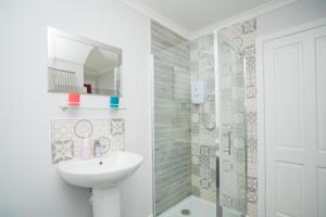 biała łazienka z umywalką i prysznicem w obiekcie Tig Cottage - a rural, quirky, pet friendly 2 bedroom cottage near Ballantrae w mieście Ballantrae