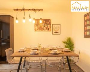 a dining room with a wooden table and chairs at NEC, HS2 & Airport Stay Home By Lush Properties - 3BR House In Shard End, Birmingham in Birmingham