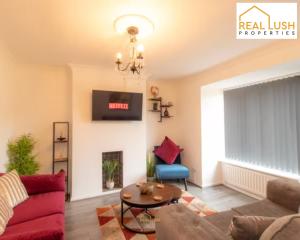a living room with a couch and a table at NEC, HS2 & Airport Stay Home By Lush Properties - 3BR House In Shard End, Birmingham in Birmingham