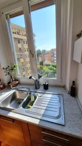 uma cozinha com um lavatório e uma grande janela em Quarto Piano - intero alloggio a Roma em Roma