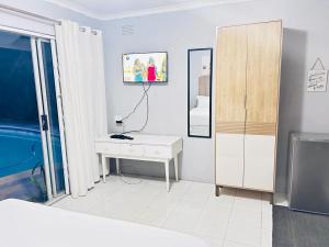 a white room with a desk and a mirror at Decent Stay in Durban