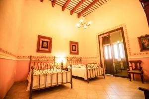 a bedroom with two beds and a chandelier at Hotel Boutique La Mision De Fray Diego in Mérida