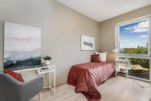 um quarto com uma cama e uma grande janela em New Build Luxury Apartment OSLO em Lorenskog