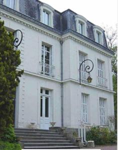 a large white building with stairs in front of it at Dormez Hors des 4 Temps { Maison Bardou} in Amboise