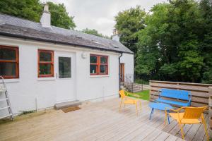 leżak z krzesłami i niebieską ławkę na domu w obiekcie Tig Cottage - a rural, quirky, pet friendly 2 bedroom cottage near Ballantrae w mieście Ballantrae