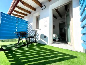 a patio with chairs and a table on the grass at Country & Beach Suites in Cardedu