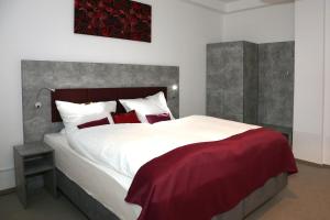a bedroom with a large white bed with red pillows at Arthotel in Bad Pyrmont