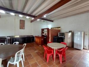a kitchen with a table and red chairs in a room at Sitio em Santa Isabel Recanto da Tranquilidade in Santa Isabel