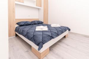 a bedroom with a bed with a black and white comforter at Casa De Hijos in Cavtat