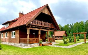 uma grande casa de madeira com um telhado de gambrel em Apartament w Bukowej Chacie em Mörken