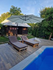 un patio con 2 tumbonas y una sombrilla junto a la piscina en Villa "Hipnotic", en Sarajevo