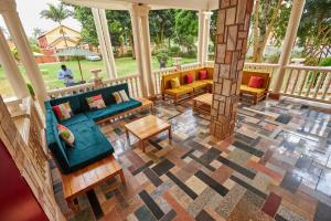 una veranda schermata con divani e tavolo di The Forest House - Kawuku-Bunga a Kampala