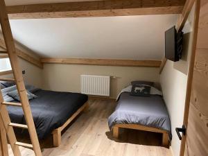 a bedroom with two bunk beds and a flat screen tv at GITE La fromagerie Haut Jura 