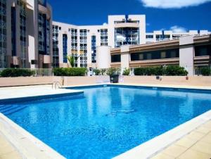 una grande piscina di fronte a un edificio di Le MARTY 9 Vue Mer Loggia Climatisé Piscine Centre a Sète