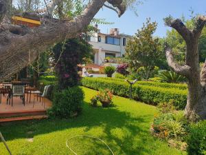 a garden with a table and chairs and a building at La capannina cilento num 11 in San Marco di Castellabate